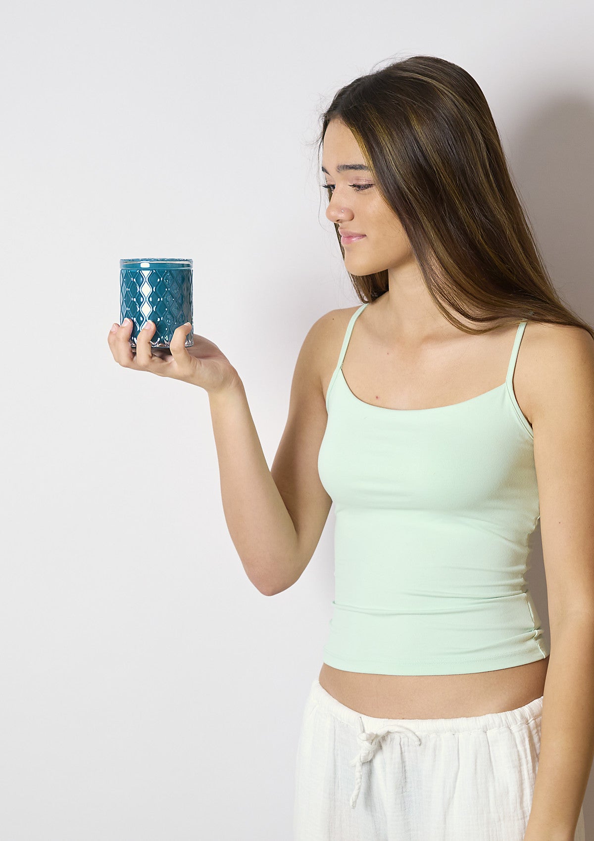 Model holding the AMARIS Deep Jade Luxe candle vessel