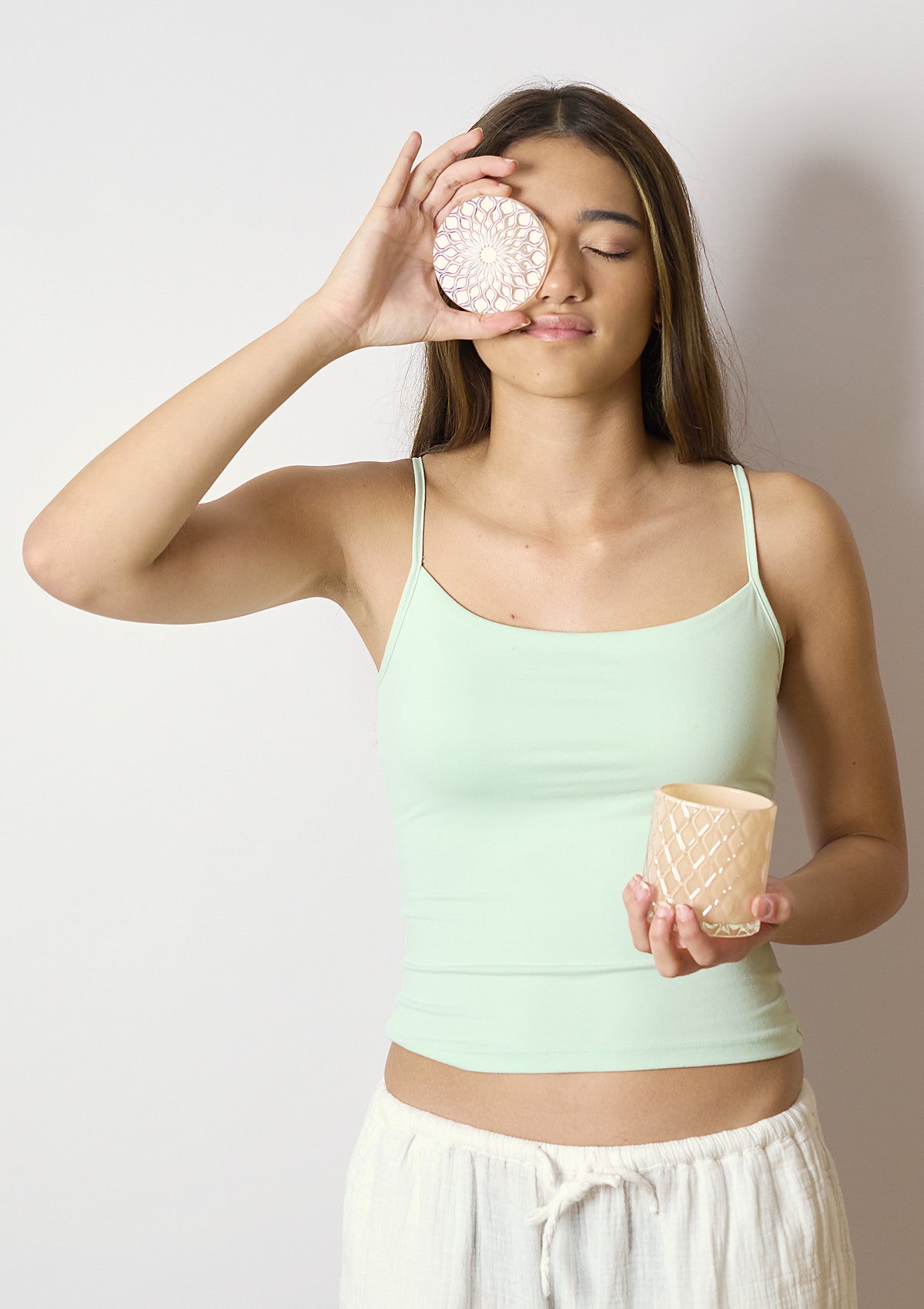 Model holding the AMARIS Shell Luxe candle vessel
