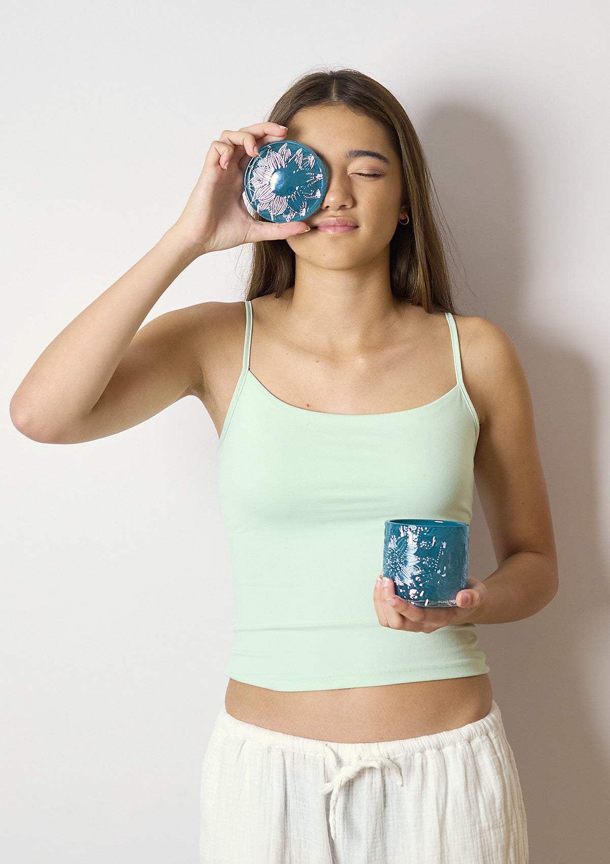 Model holding the ZIVA Deep Jade Luxe candle vessel