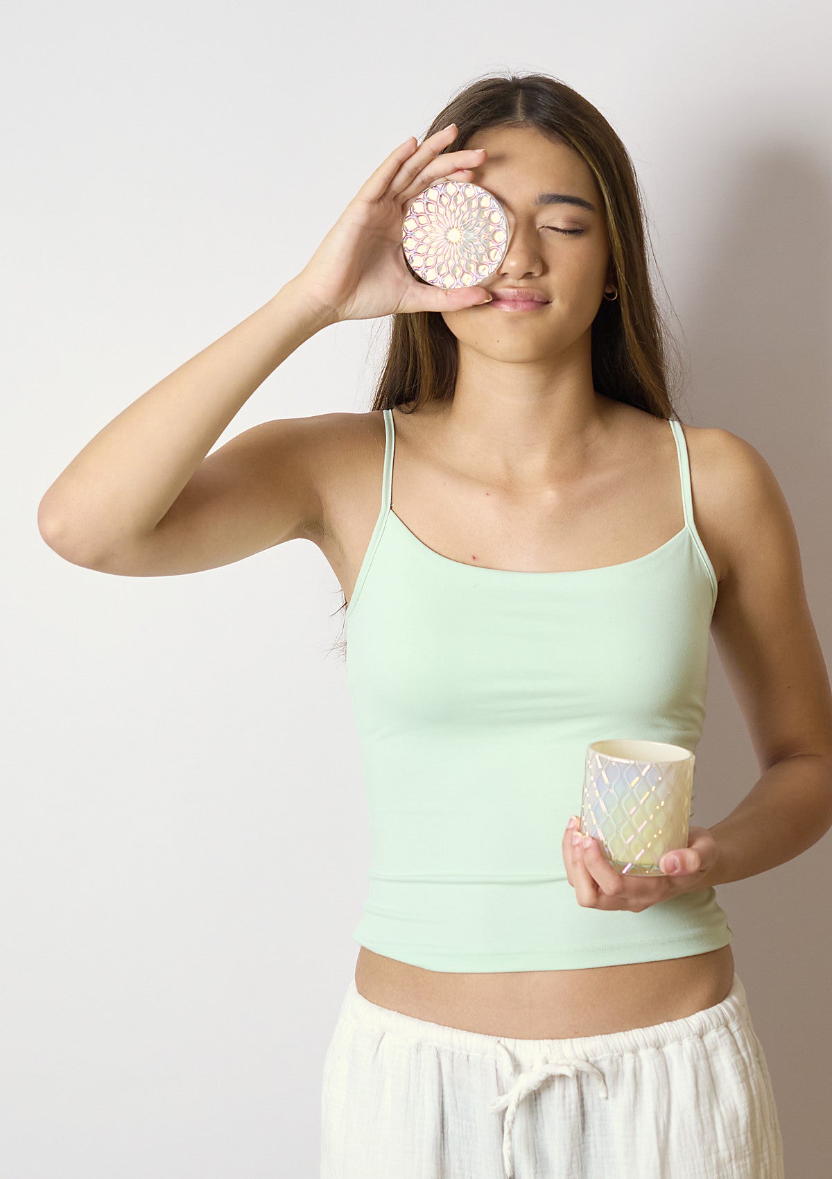 Model holding the AMARIS Coconut Cream Luxe candle vessel