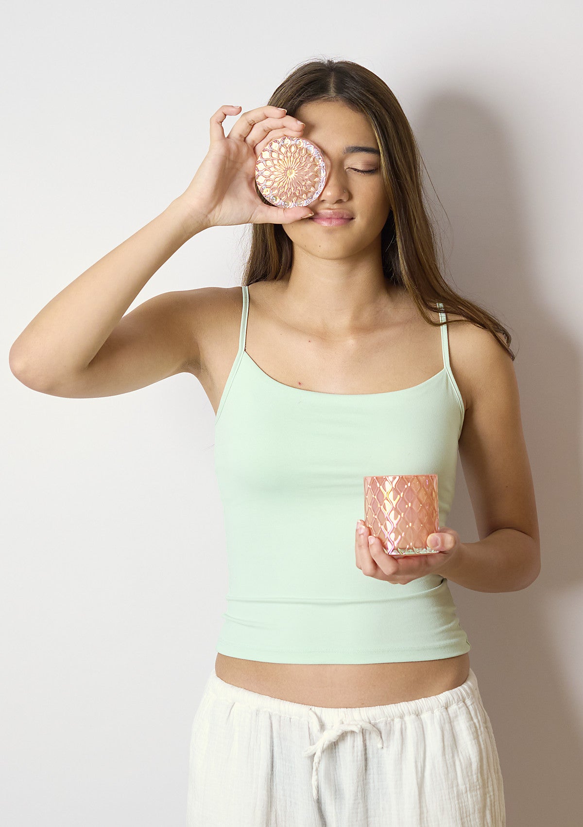 Model holding the AMARIS Peach Luxe candle vessel
