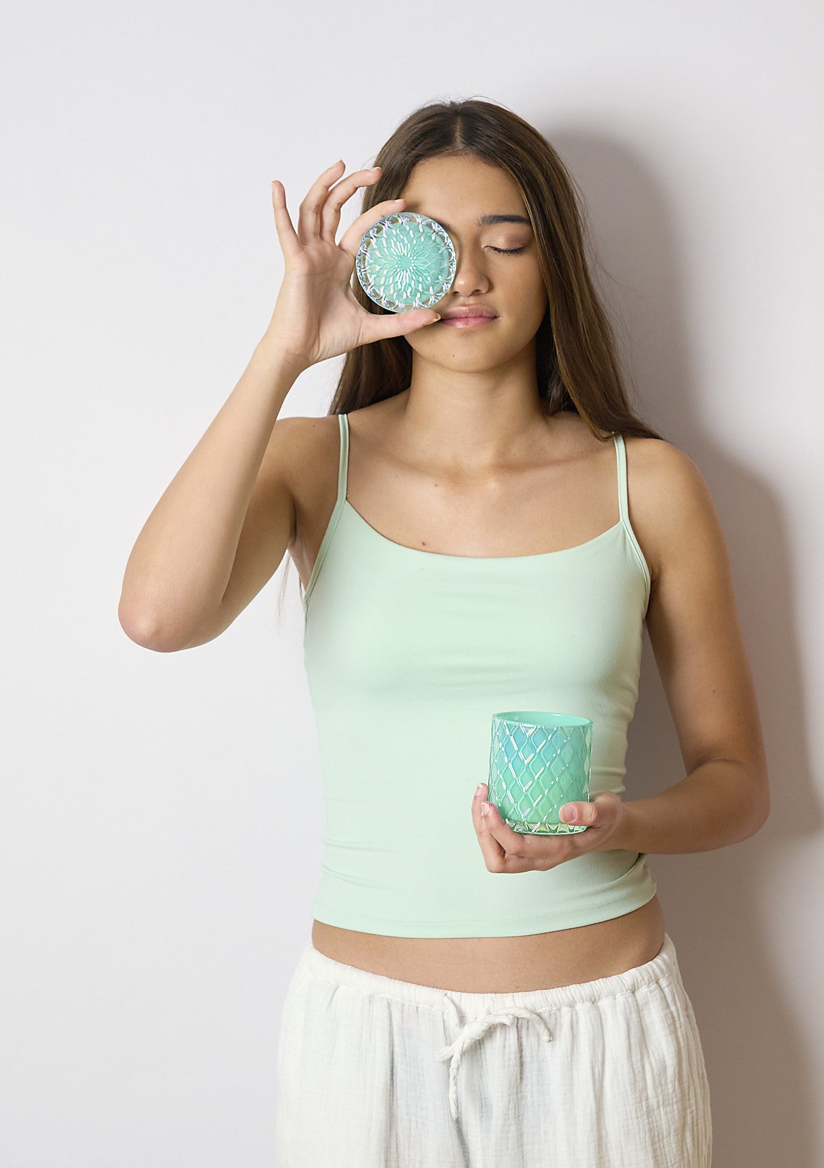 Model holding the AMARIS Turquoise Luxe candle vessel