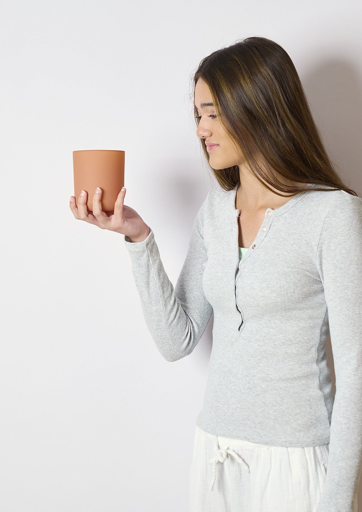 Model holding the INFINIA Matte Terracotta candle vessel