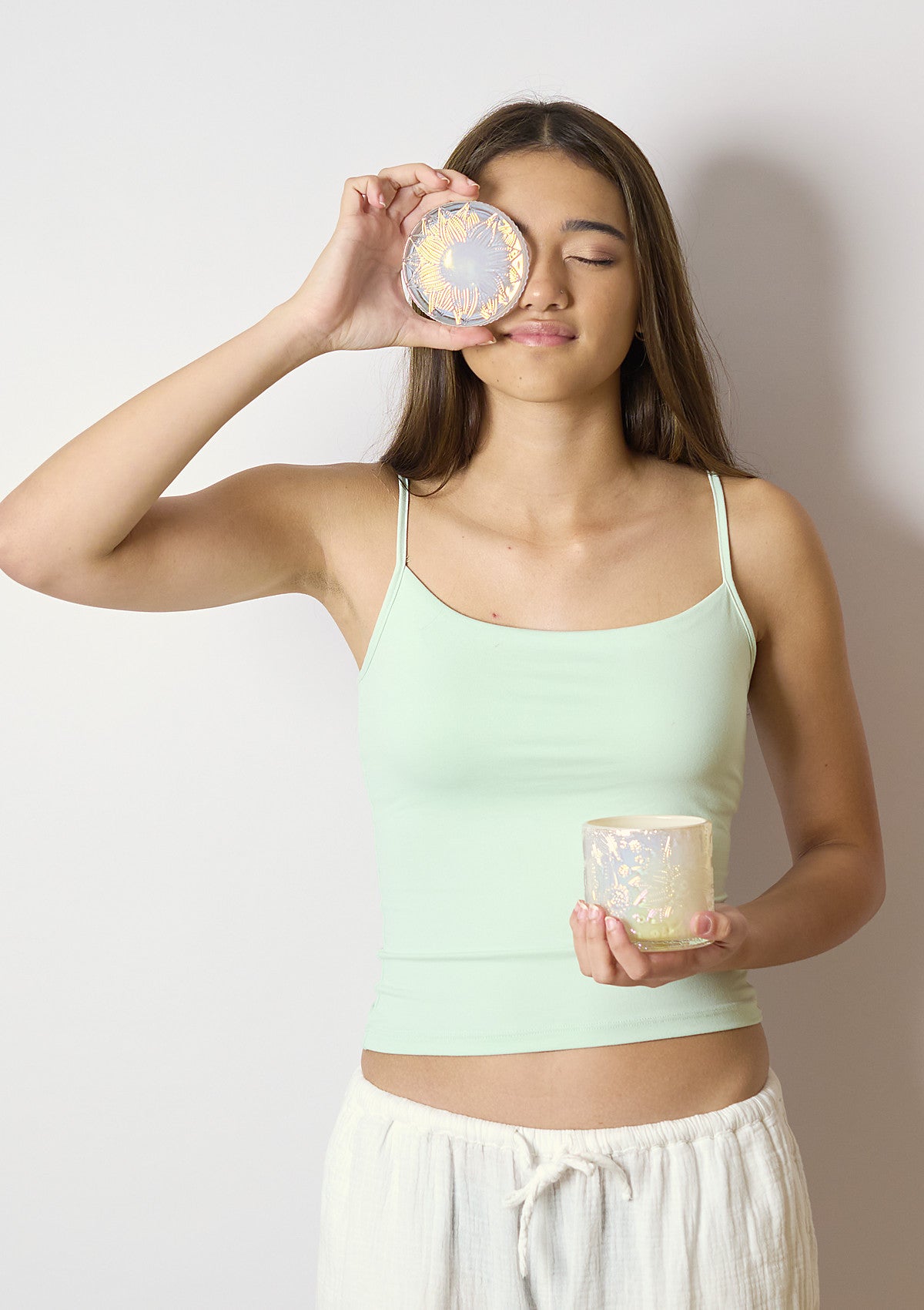 Model holding the ZIVA Coconut Cream Luxe candle vessel