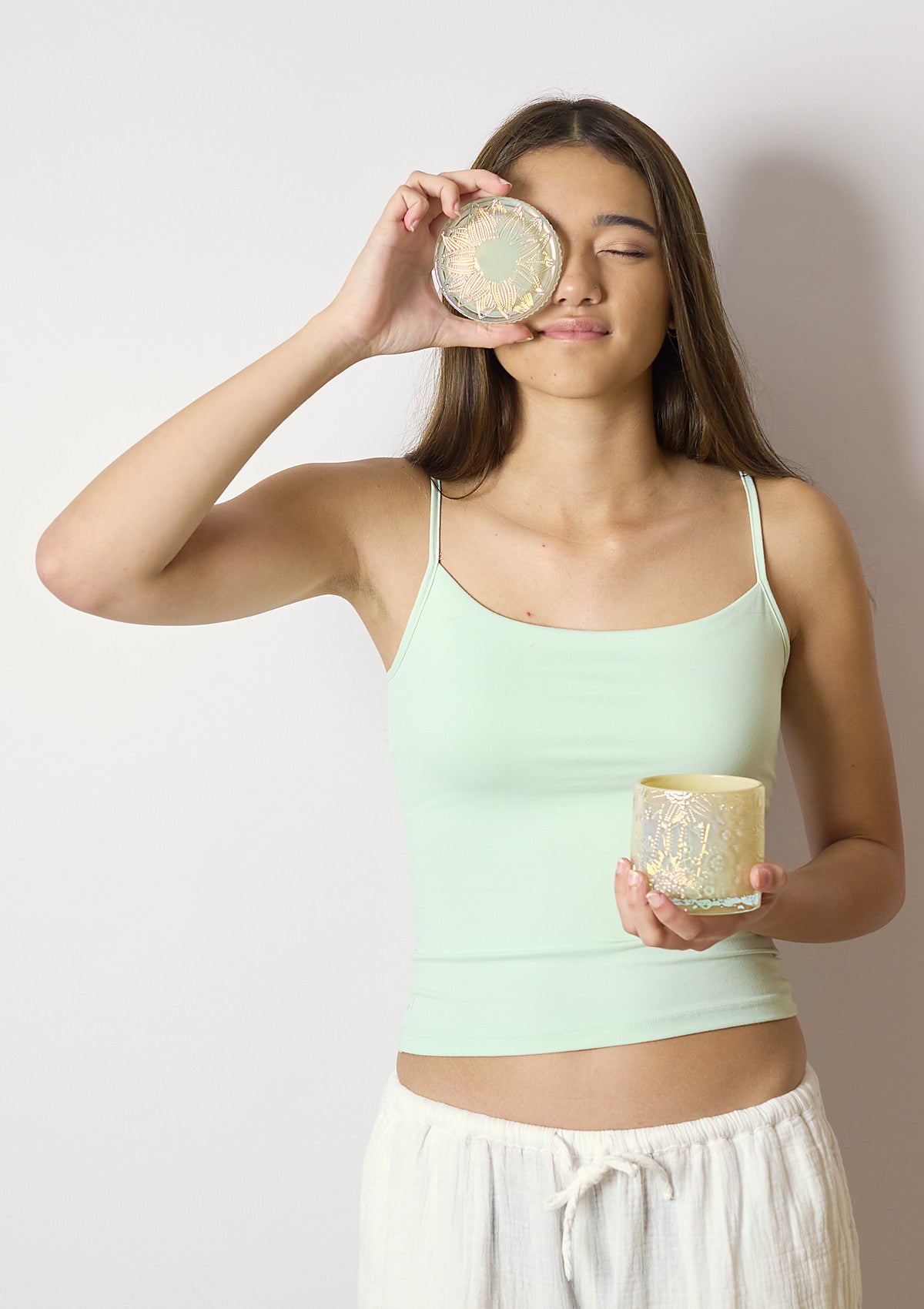 Model holding the ZIVA Tapioca Luxe candle vessel